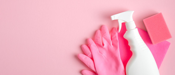 Cleaning supplies on pink background. Cleaning service banner design with spray bottle, pink gloves and sponge. Housecleaning services concept.