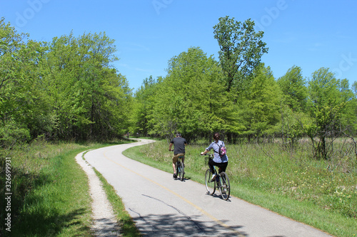 Man and woman riding bicycles on the North Branch Trail at Bunker Hill Woods in Chicago