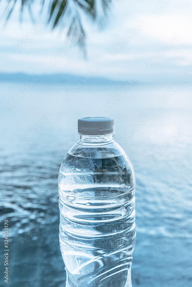 Plastic water bottle on the background of the sea landscape of the island. Fresh and clear clear water. Plastic water bottle on the background of the sea landscape of the island. Fresh and clear clear water.
