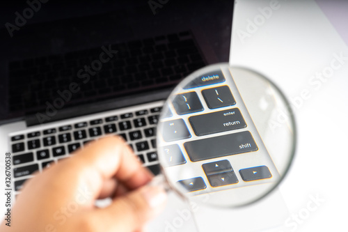 Magnifier and laptop with technology concept.