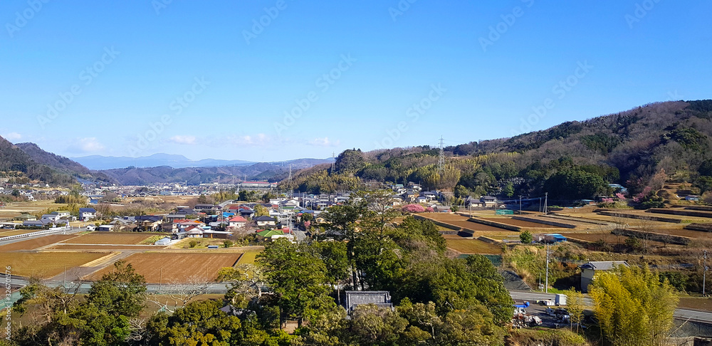 Landscape view with city or village, tree, green mountain and clear blue sky at Shizuoka, Japan. Beauty in nature and local area 
