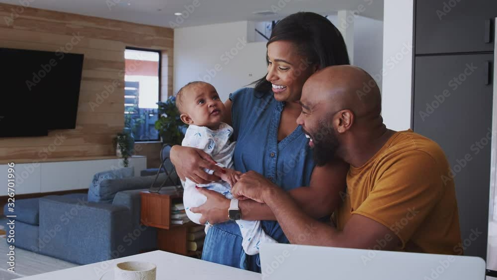 African American Family With Baby Daughter Using Laptop To Check Finances At Home African American Family With Baby Daughter Using Laptop To Check Finances At Home