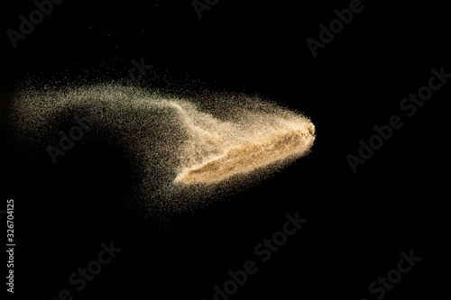 Dry river sand explosion.Brown color sand splash against black background.