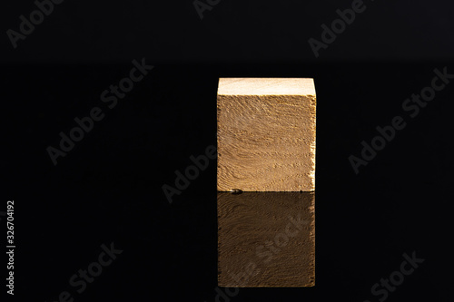Wooden cube and black background in low light view.