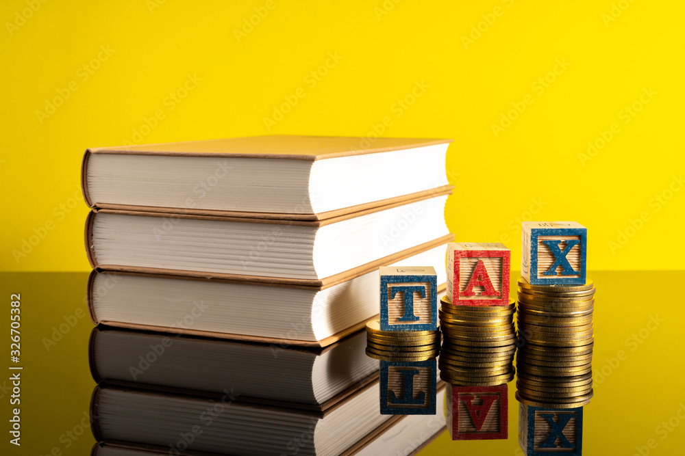 TAX letter and stacking coins with financial concept. Image in low light view. TAX letter and stacking coins with financial concept. Image in low light view.