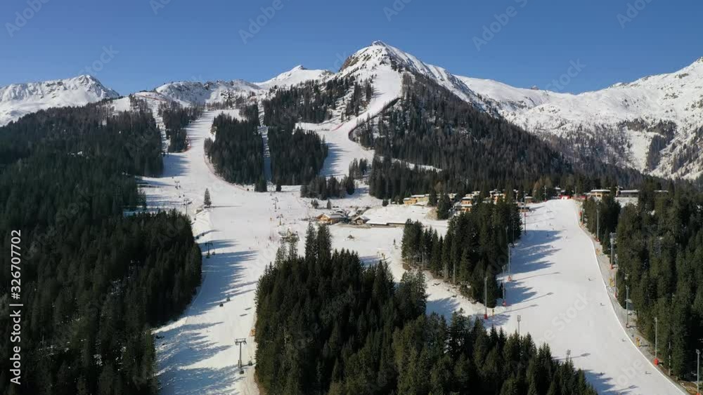 Aerial view of Italian Alps and ski slopes in Madonna di Campiglio ski resort, winter mountain scenery with skiers skiing downhill on slopes covered with snow - Italy from above, Europe Aerial view of Italian Alps and ski slopes in Madonna di Campiglio ski resort, winter mountain scenery with skiers skiing downhill on slopes covered with snow - Italy from above, Europe