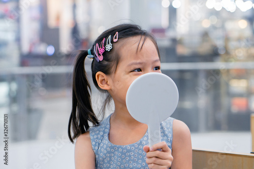 Schilderij op canvas Little asian girl preparing for ear piercing process