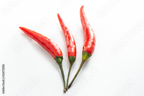 Three Fresh red peppers are isolated on white background.