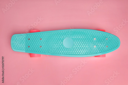 Penny board on pink background with copy space. photo