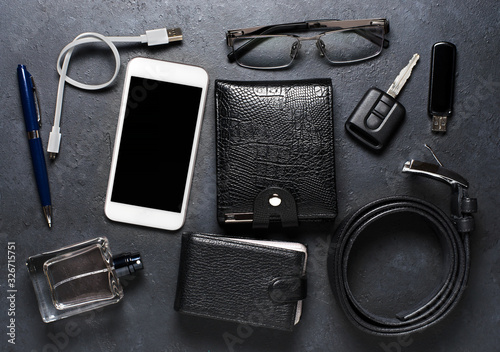 Men's accessories on a black concrete background. The concept of a successful modern man