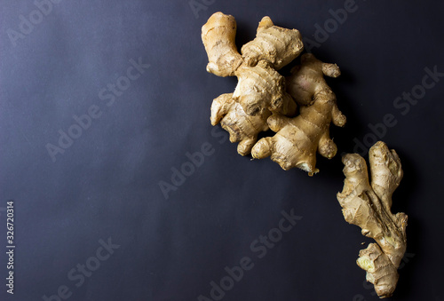 Ginger roots from above on black background. Plenty of free text space. Side lighting