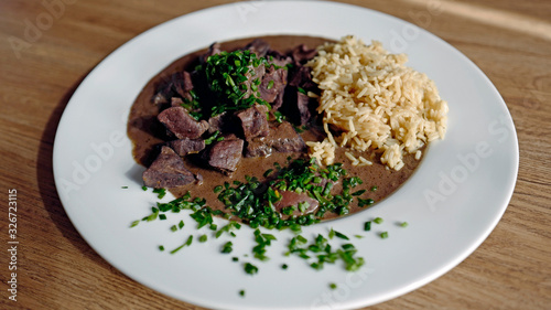 roasted liver, heart and kidneys from a red deer with sauce and rice