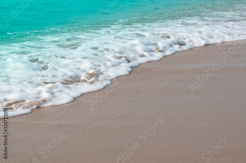 Idyllic tropical beach with Soft waves of turquoise ocean water