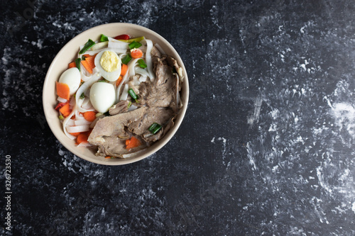 Plate with Asian soup on a dark background. photo