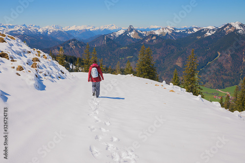 young woman at snowy wallberg mountain, hiking trail down, early springtime