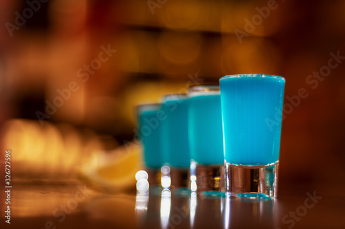 Fotografie blue kamikaze shots on wooden table close up