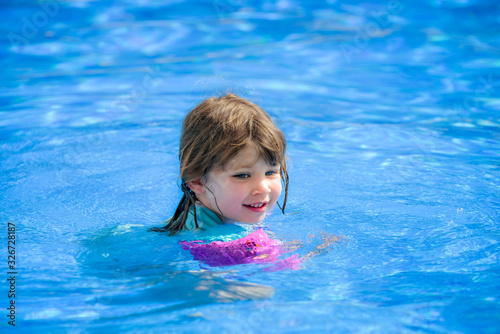 portrait of a pretty little girl playing in a swimming pool