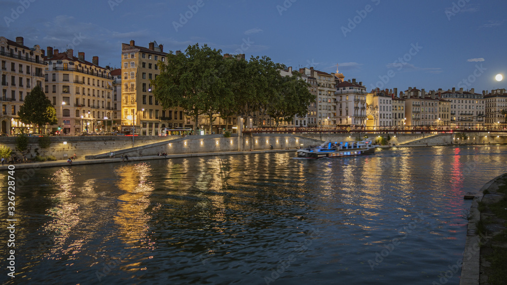 Naklejka premium Ballade en vélo, à Lyon, de jour comme de nuit, sur les quais de la rivière Saône.