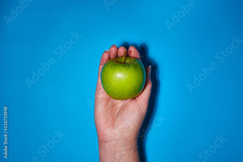 Lemon in hand on blue background. Flat lay, top view, copy space . Food dietary concept.