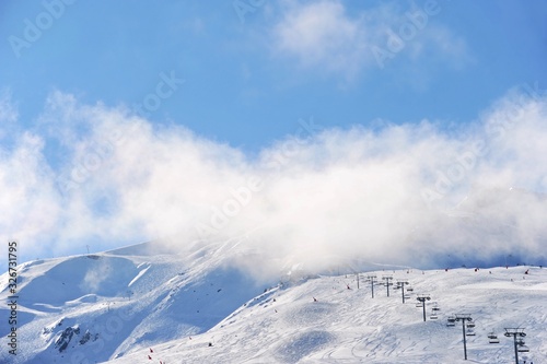 Ski resort view with chair lifts under clouds and snow  © raeva