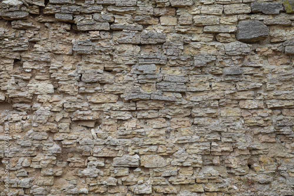 The brown and grey cobblestone or brick tower, fortress or castle wall background or texture The brown and grey cobblestone or brick tower, fortress or castle wall background or texture