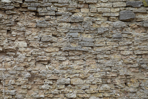 The brown and grey  cobblestone or brick tower  fortress or castle wall background or texture