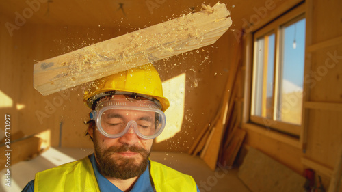 Photos PORTRAIT, CLOSE UP: Wooden board falls on an unsuspecting builder's head