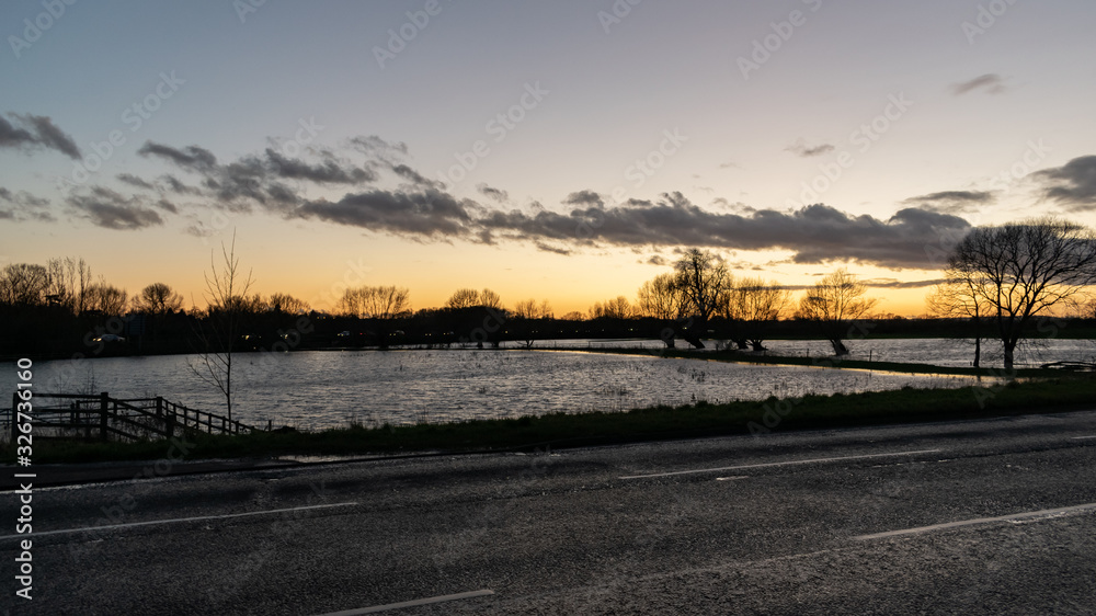 Floods in Thame town, Oxfordshire winter floded lands, sumset by the water, river overflow for new animal habitat