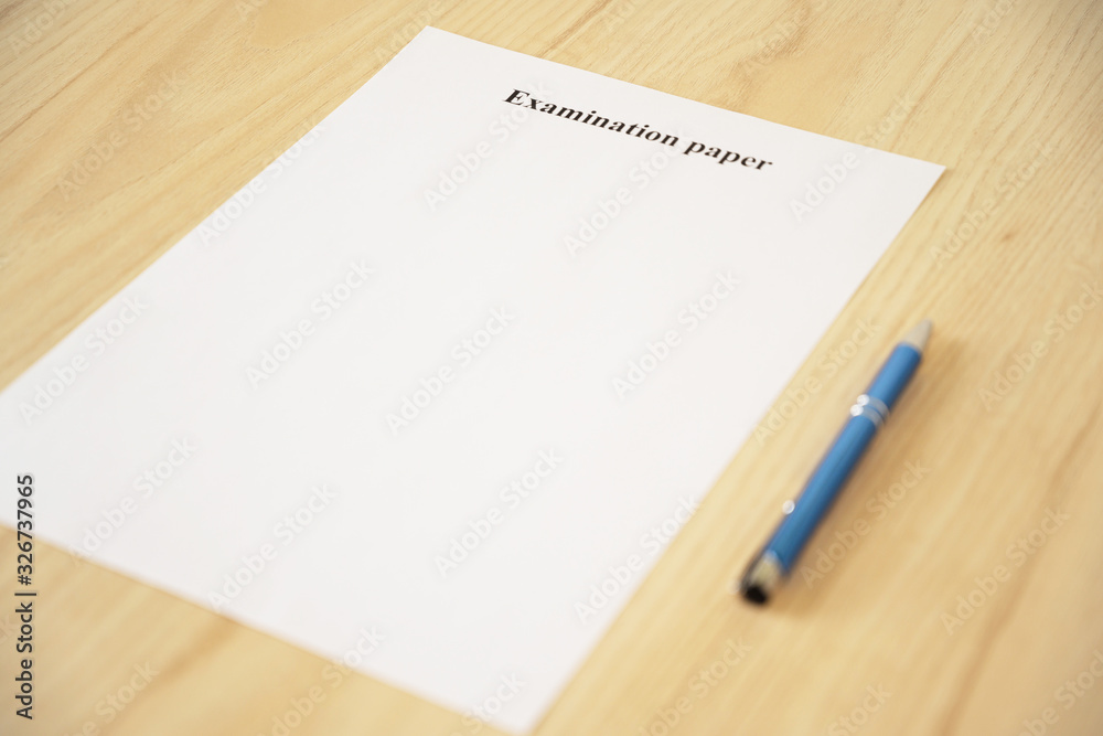 Empty examination paper for university with pen on the school desk. Copyspace. Mockup. Flat lay