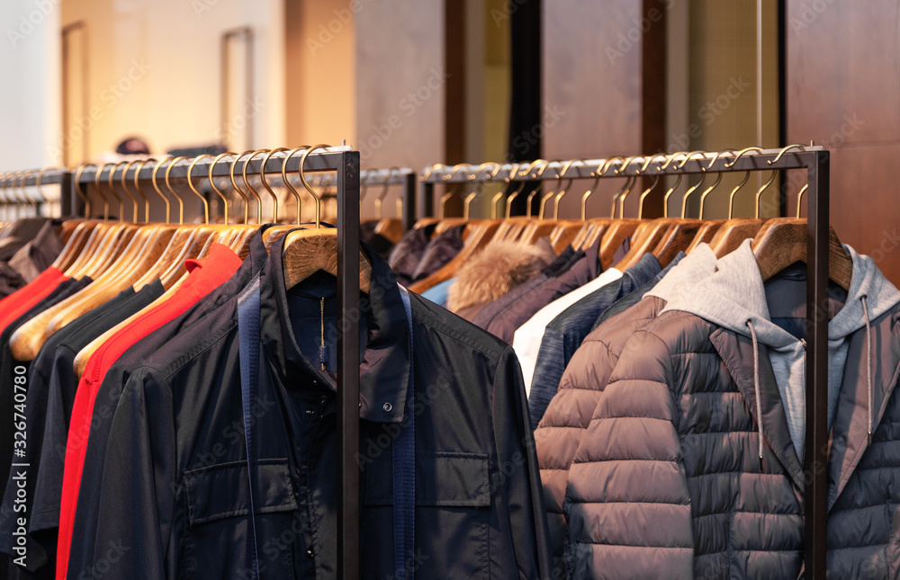 Closeup colorful male, female clothes in boutique hanging on hangers, clothing  rack on metal stand. Concept opening luxury shop, shopping mall, store  sale, retail fashion store, second hand outlet. Stock Photo