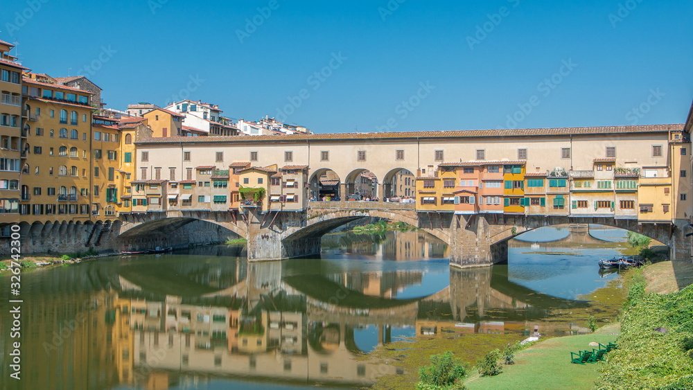 View on The Ponte Vecchio on a sunny day timelapse, a medieval stone segmental arch bridge over the Arno River, in Florence, Italy
