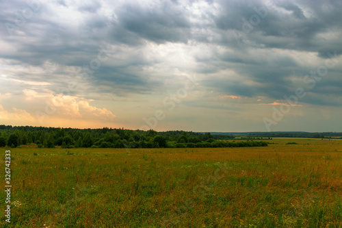 Picturesque clouds float over a wild meadow. The approaching storm. Ivanovo region, Russia. © 1802185