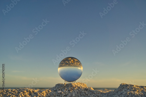 Nahaufnahme einer Glaskugel am Strand auf Sanibel Island mit Meer und Horizont im Hintergrund photo