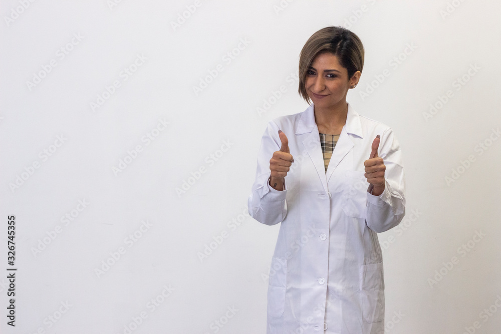 Portrait of happy confidence latin young woman showing thumbs up gesture. Doctor, nurse, pharmacist, beauty therapist, scientist, healthcare, isolated on white background studio shot, in white coat un Portrait of happy confidence latin young woman showing thumbs up gesture. Doctor, nurse, pharmacist, beauty therapist, scientist, healthcare, isolated on white background studio shot, in white coat un
