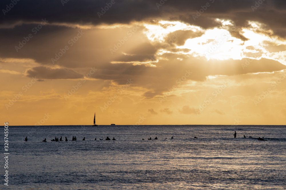 Waikiki surfers enjoying the sea at Hawaiian sunset