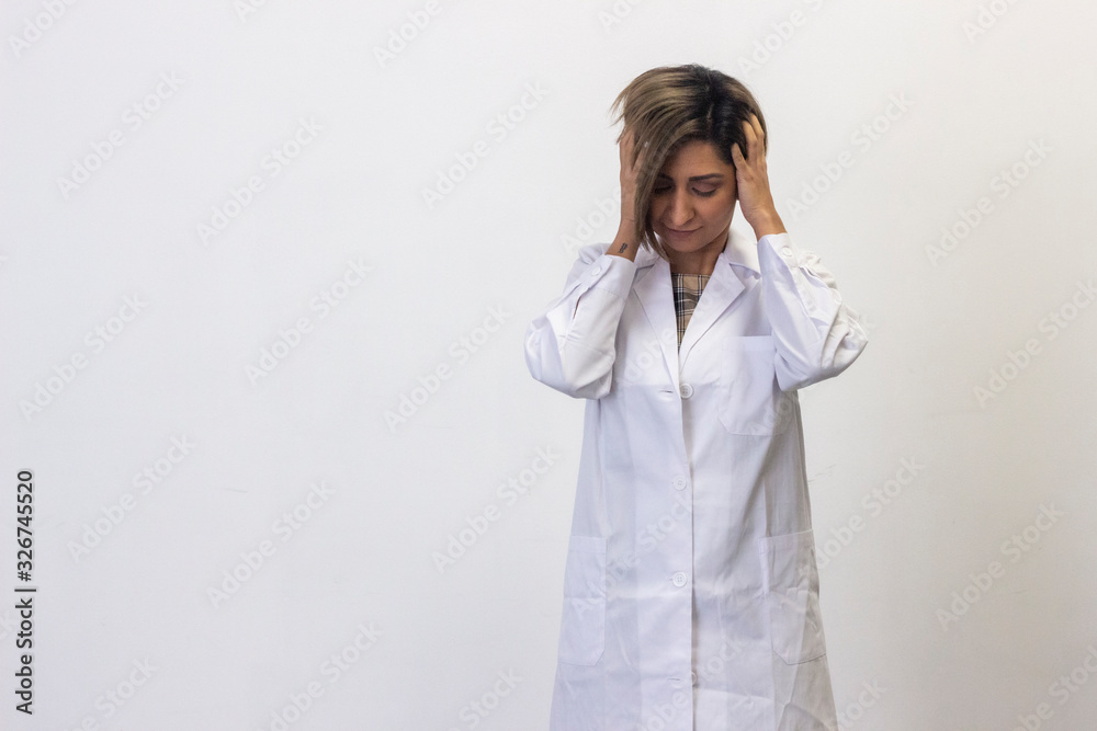Portrait of attractive latin young woman model keeps hand on head, grimaced, has problems, being in bad mood, has terrible headache. Doctor, nurse, pharmacist, isolated on white background studio shot Portrait of attractive latin young woman model keeps hand on head, grimaced, has problems, being in bad mood, has terrible headache. Doctor, nurse, pharmacist, isolated on white background studio shot