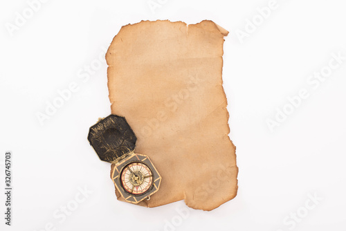 top view of vintage compass on aged empty paper isolated on white