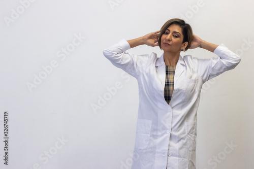 Portrait of relaxed latin young woman model touching his head with both hands, having time for rest, looks quiet and peaceful. Slender charismatic man poses. Doctor, nurse, isolated on white backgroun
