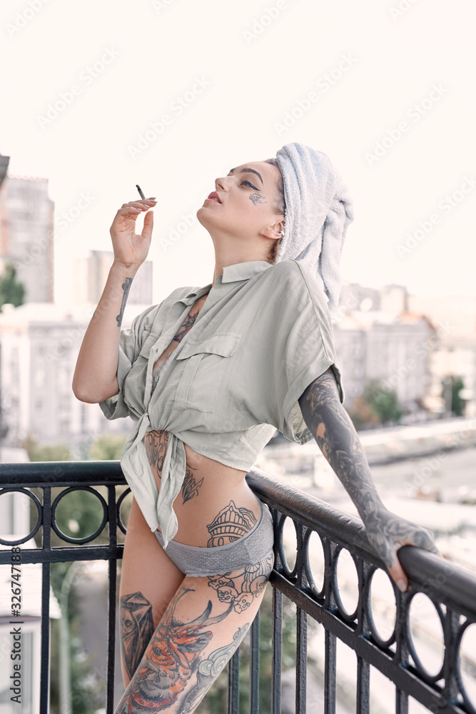 Home Leisure. Young woman in underwear and towel standing on balcony smoking drugs joyful - obrazy, fototapety, plakaty 