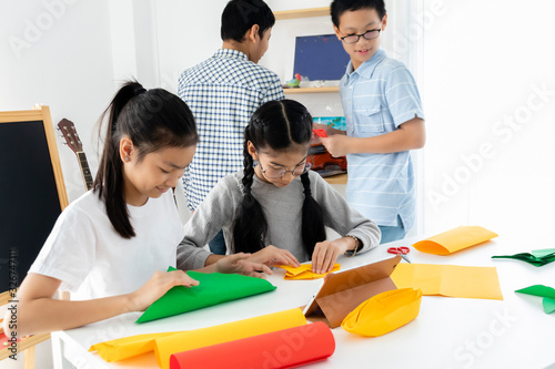 Young diversity Asian students enjoy activity in classroom. Boys, girls learning together by use colorful paper. Integrated school educate children in an environment where self-esteem and independence