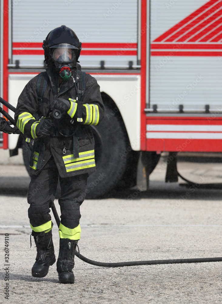 Naklejka premium fireman with respirator with oxygen cylinders during extinguishi