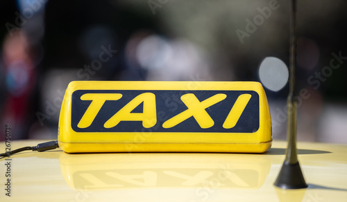 Taxi sign yellow coloe detail, defocused city street background