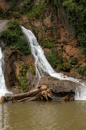 Woman Enjoying herself at the Waterfall known as Cachoeira Paraiso do Cerrado located near the city of Mambia and Damianopolis in the State of Goias, Brazil. photo