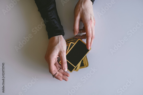 Billede på lærred top view stack of fortune telling cards and a woman's hands on a white table, di
