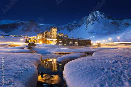 Ski resort at night. French Ski resort Tignes, beneath towering mountains, night time Blue Hour.  Skiing Snowboarding photo