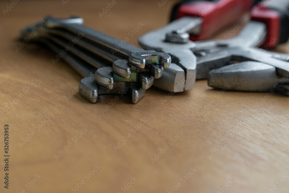 Set of small wrenches. Tool for bolts. Household tools on a wooden table. Set of small wrenches. Tool for bolts. Household tools on a wooden table.
