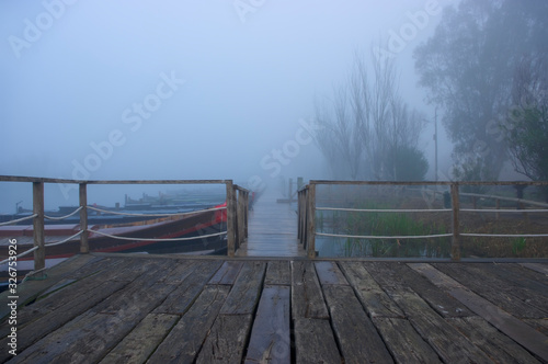 Wooden walkway with fog in the port of Catarroja Valencia Spain.