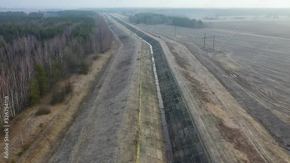 Irrigation system, large concrete canal with very low water level until can see the floor below. View from above Irrigation system, large concrete canal with very low water level until can see the floor below. View from above
