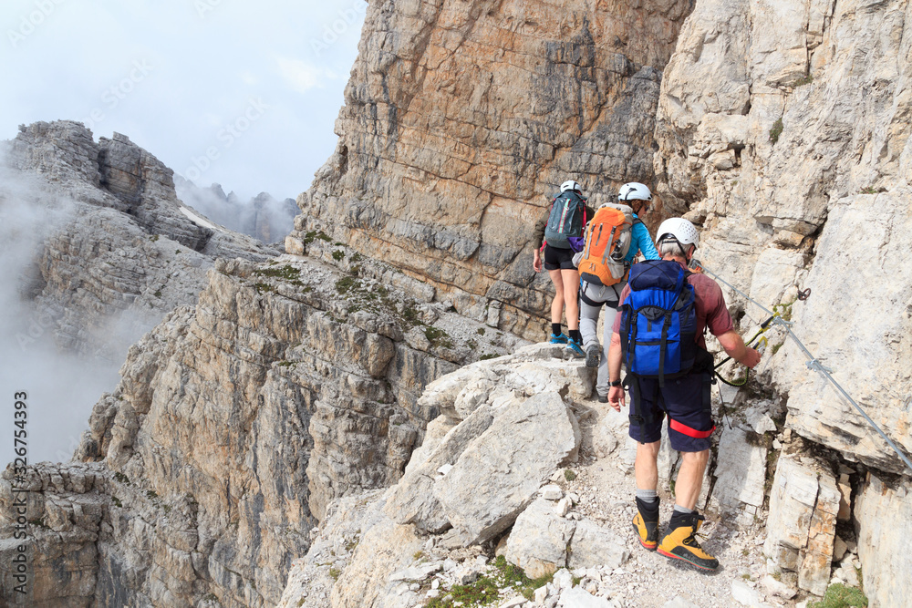 People climbing the Via Ferrata Sentiero Benini in Brenta Dolomites mountains, Italy