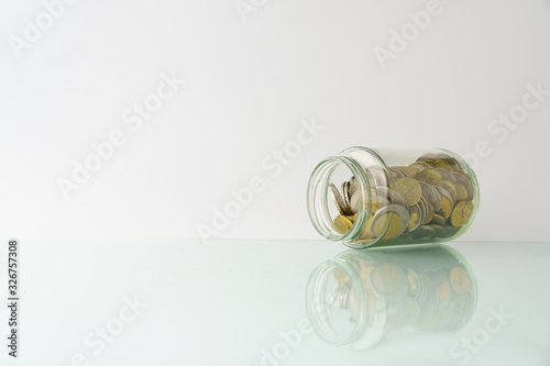 high key. business and finance management conceptual images. bottle of coins isolated against white background with reflection. copy space